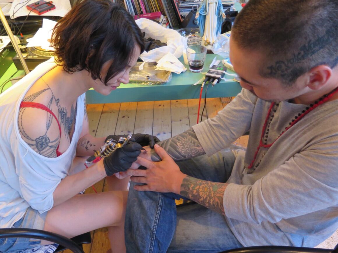 Asia makes tattoo to Akilla, courtesy of Akilla