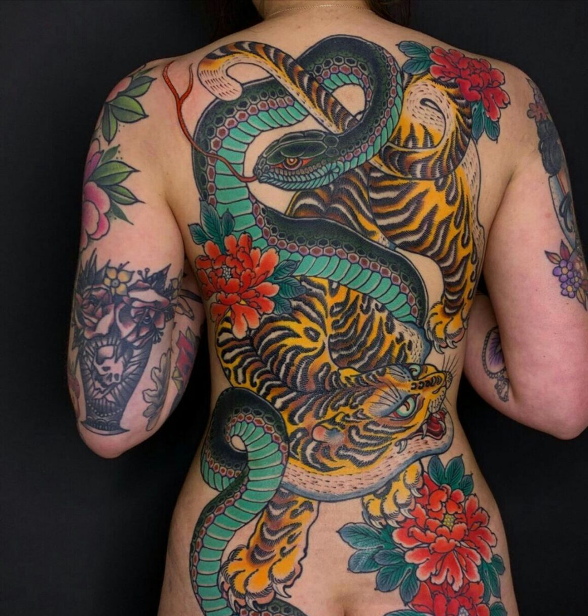 Fine line snake tattoo on the lower back