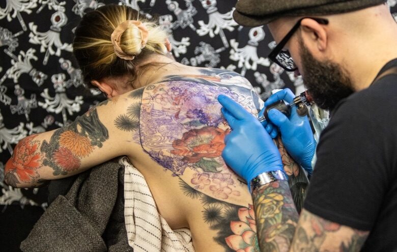 Artist works on backpiece at Brighton Tattoo Convention